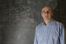Yannick Meurice in front of a blackboard with equations