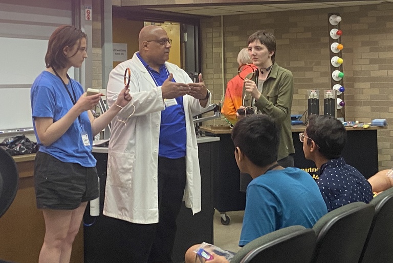 Prof. Vincent Rogers shows high school students a physics demo
