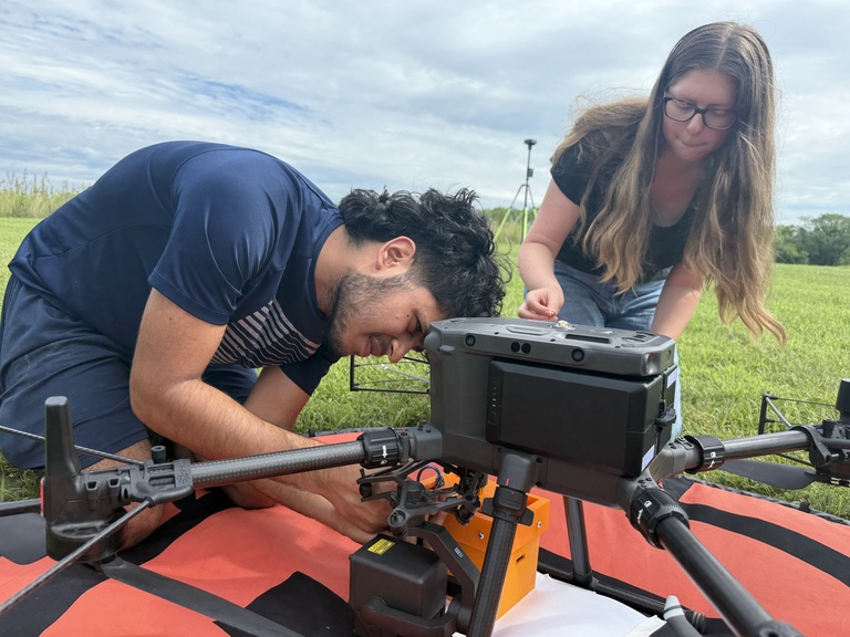 Edge of Space students work on payload attached to a drone