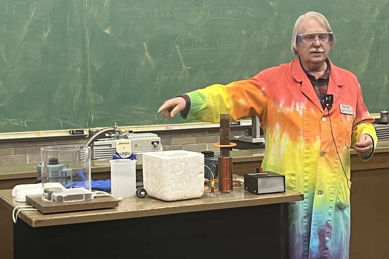 Dale Stille, an Instructional Resource Specialist at the University of Iowa, is performing a physics demonstration involving electromagnetism or low-temperature physics