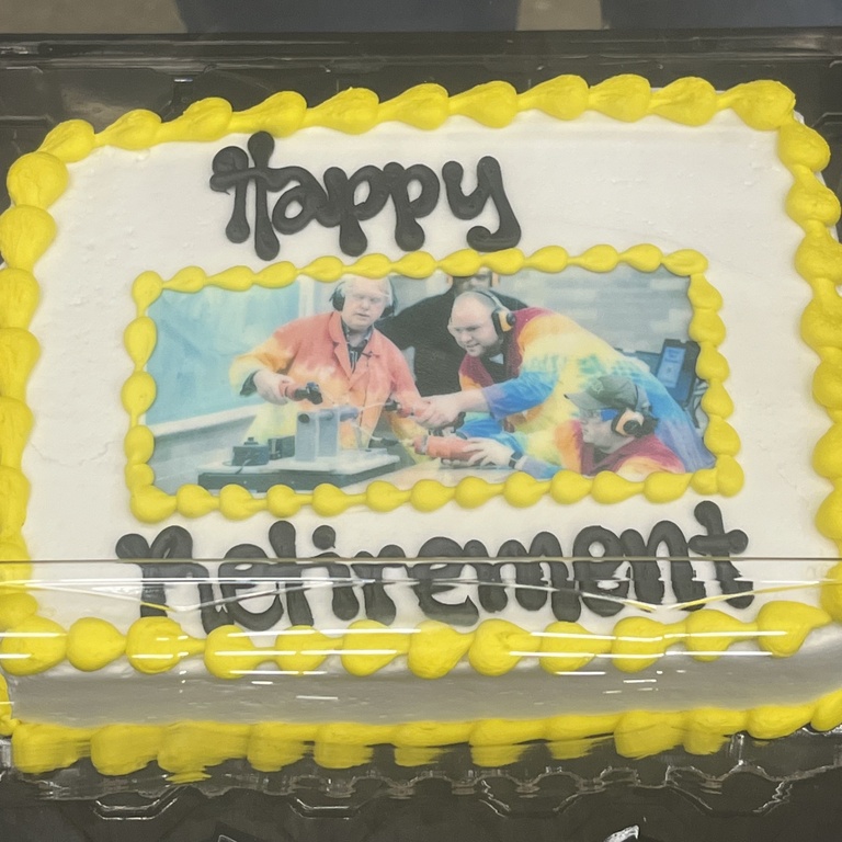 a cake with an picture of Dale Stille and students with the words Happy Retirement