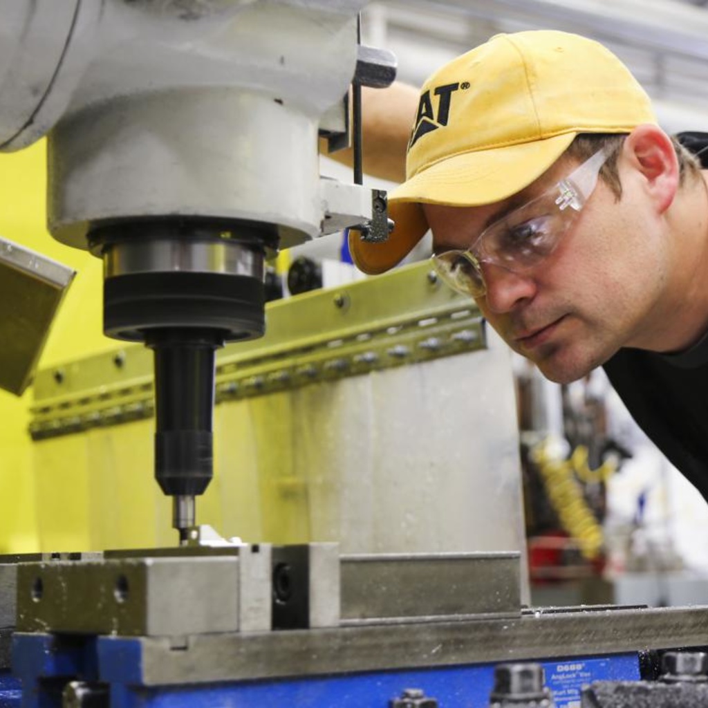 machine shop staff member views machining device