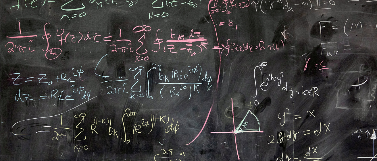 Physics equations written on a classroom blackboard.