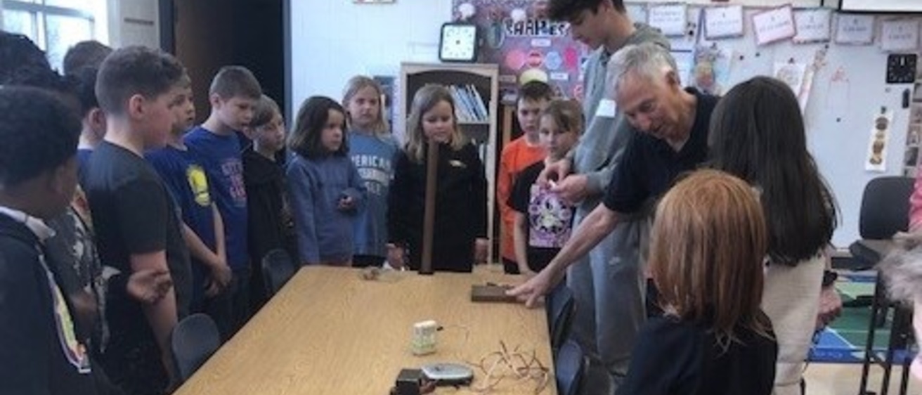 Prof. Wayne Polyzou demonstrates a device to school children