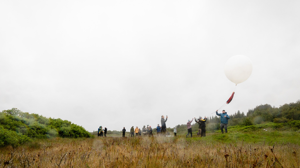 Members of the University of Iowa team watch a weather balloon ascend during their July expedition in Iceland.